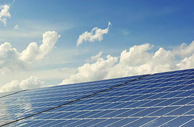 Photovoltaikmodule vor blauem Himmel mit Wolken