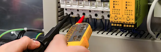 Foissner und Abt Elektrotechnik – Elektriker misst an einer Schaltanlage